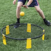 A player is playing spike ball on a green turf field.